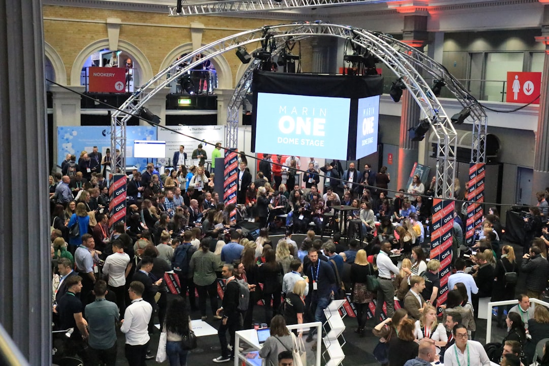 Crowd gathered at an indoor event with a large screen