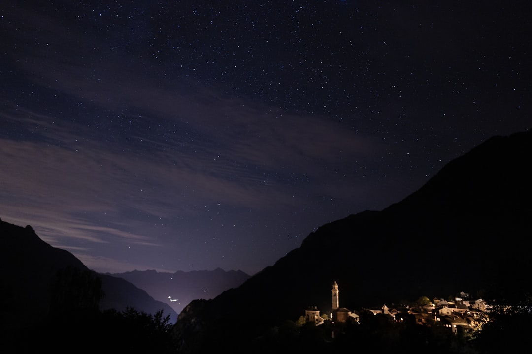the night sky with stars above a village