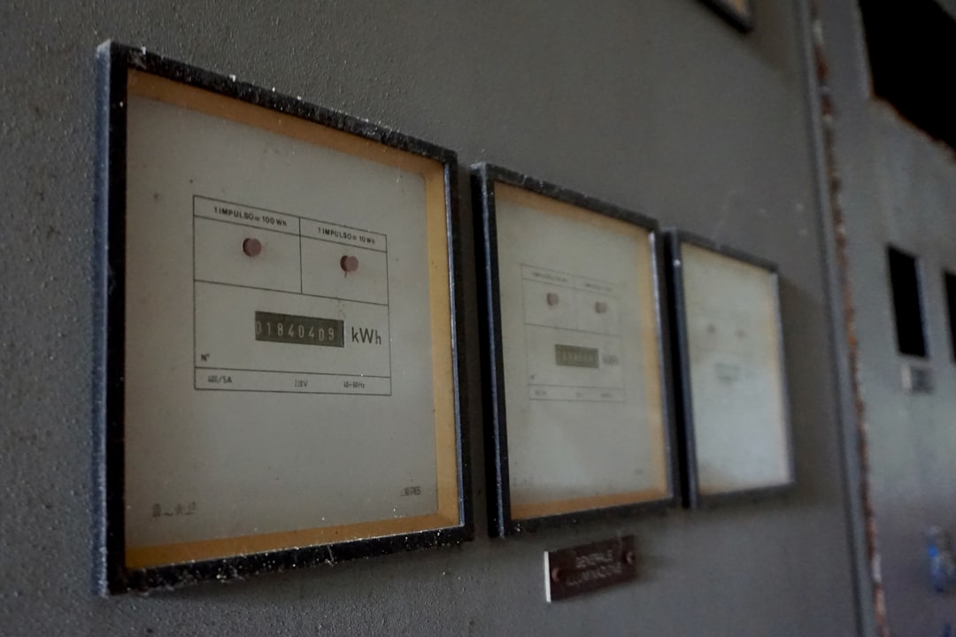 Three vintage analog meters on a gray wall