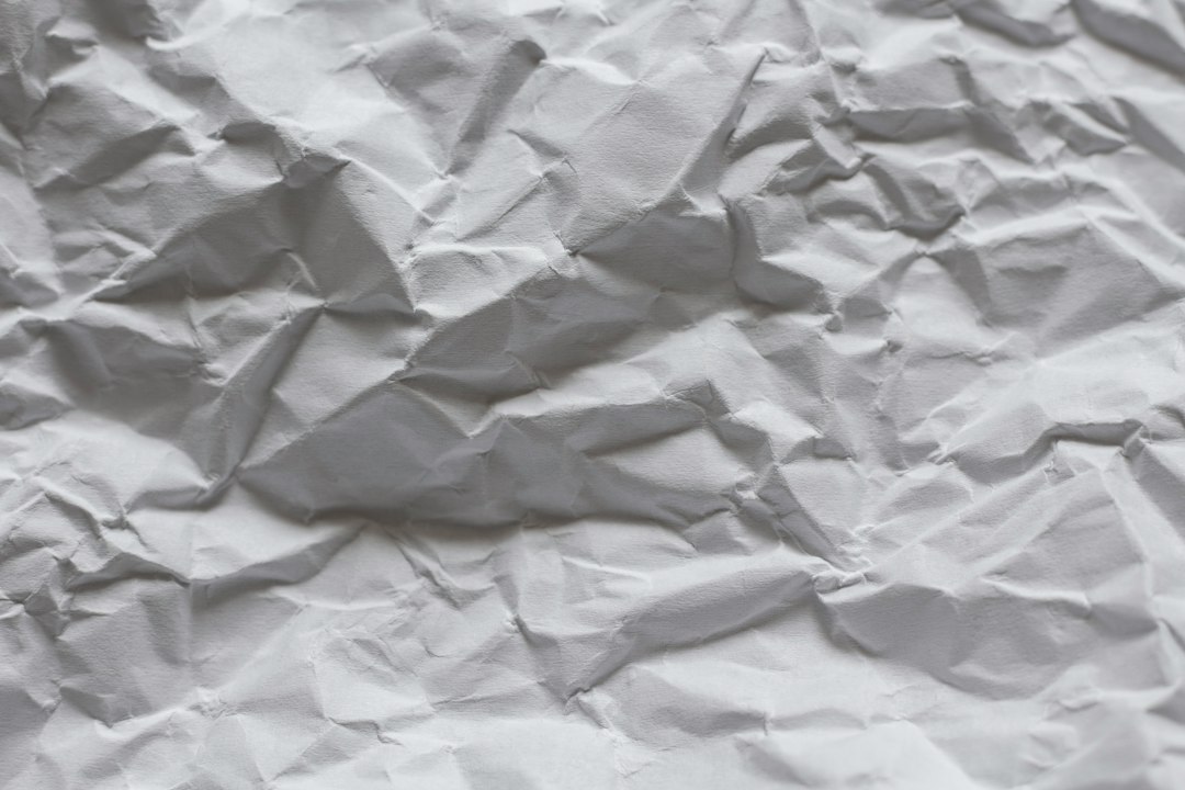 A sheet of white paper with deep creases and shadows