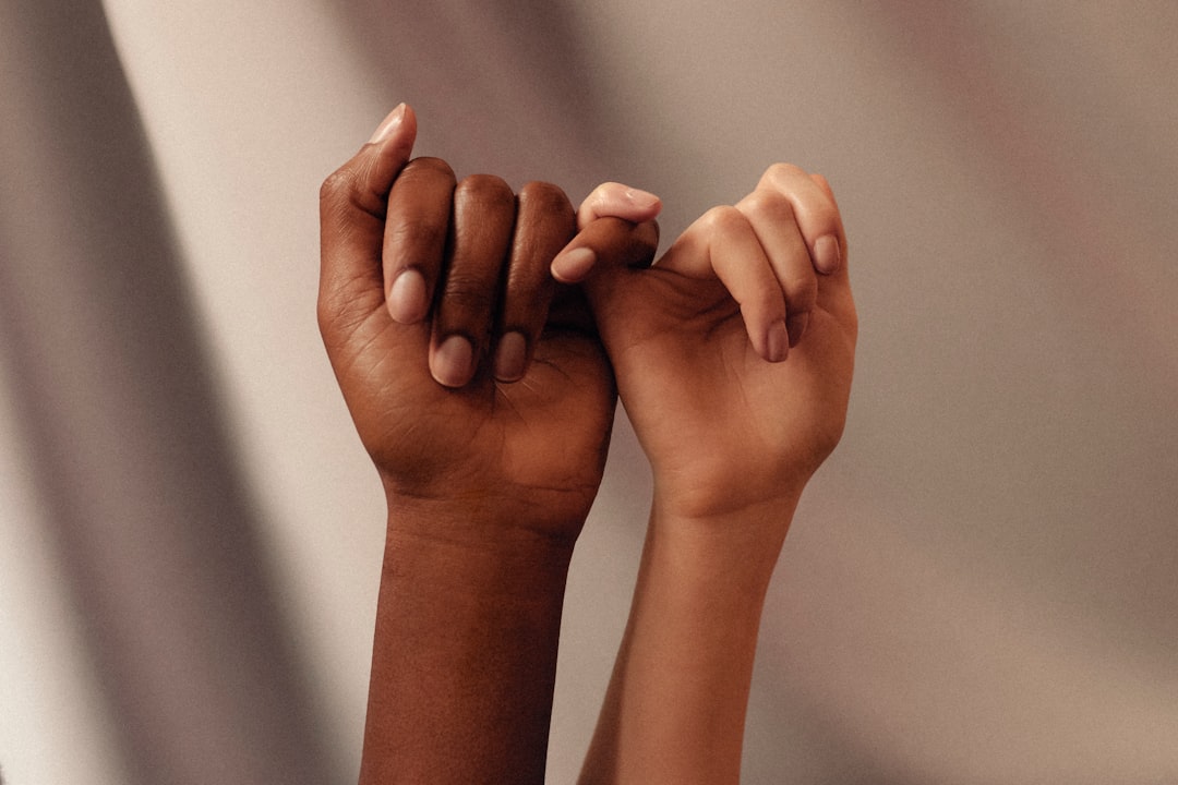 two hands with linked pinky fingers