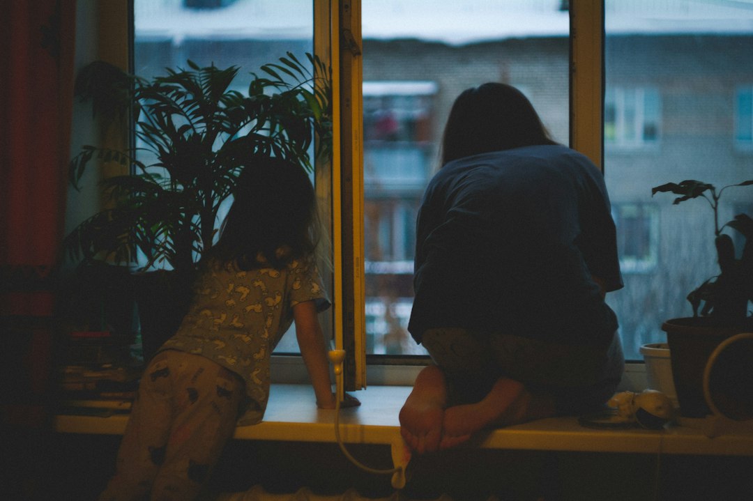 Two people looking out a window at night
