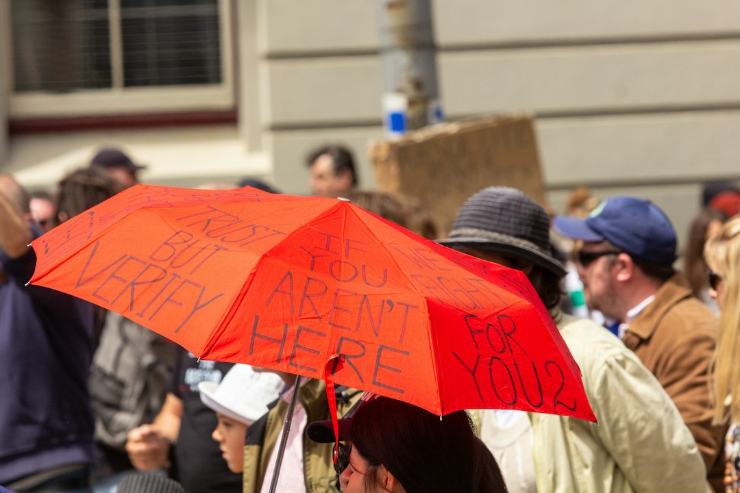 a woman holding a red umbrella with writing on it