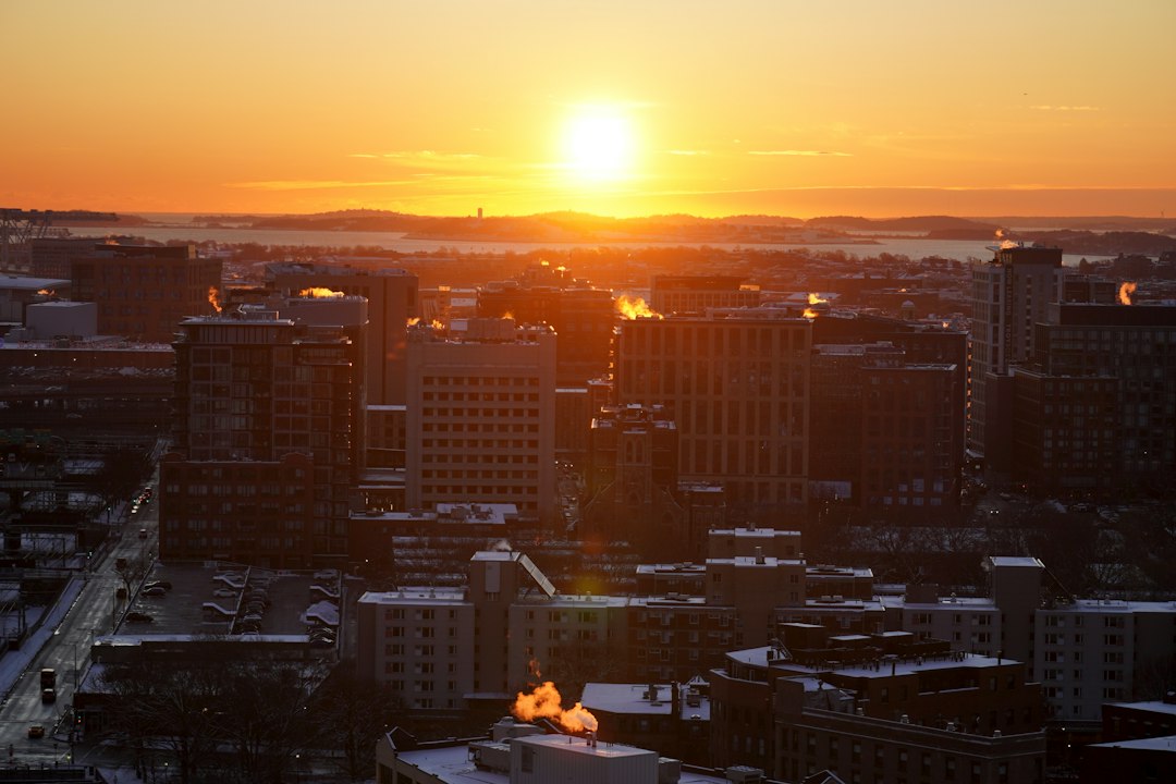 The sun is setting over a city with tall buildings