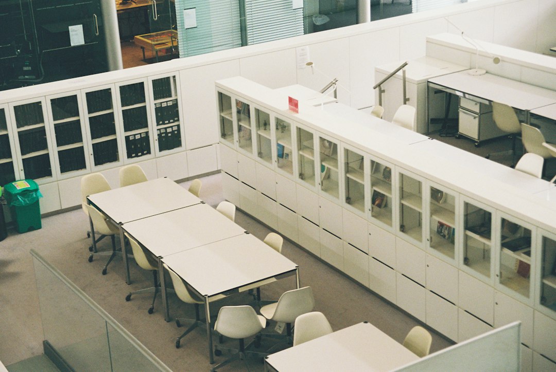 Glass-fronted archive cabinets and study tables in a bright university reading room