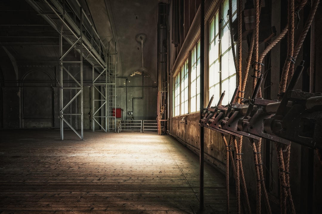 Abandoned industrial interior with large windows and metal structures