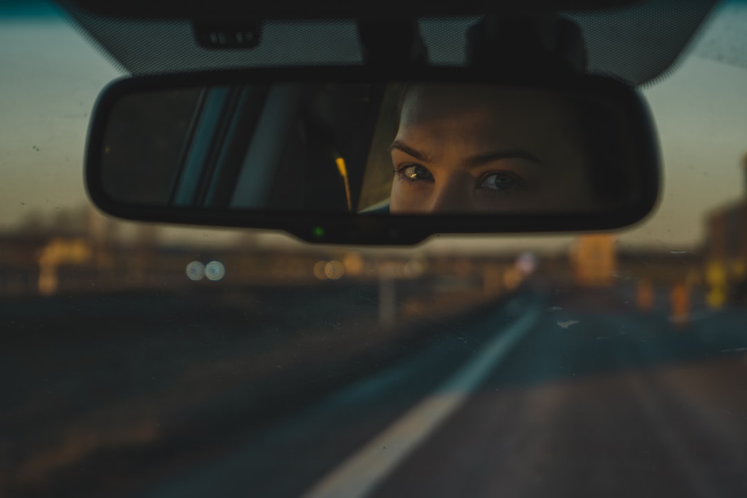 a woman's reflection in a rear view mirror