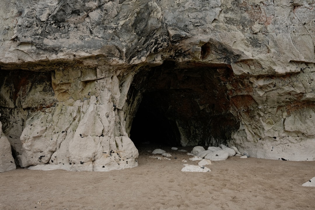 Entrance to a dark cave in a rocky cliff